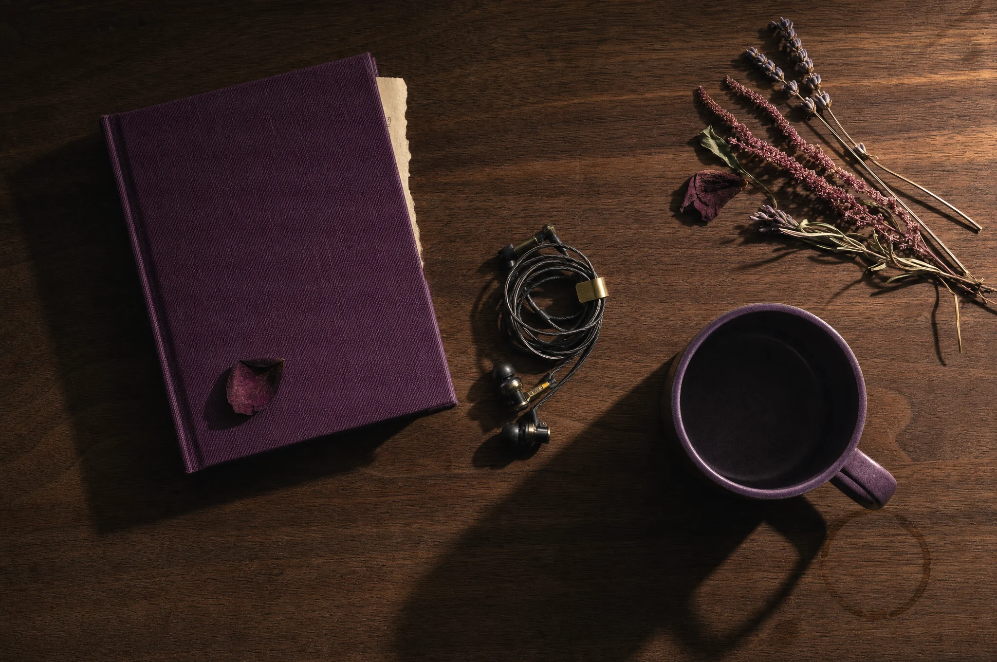 Caderno, caneca e pequenos objetos sobre madeira